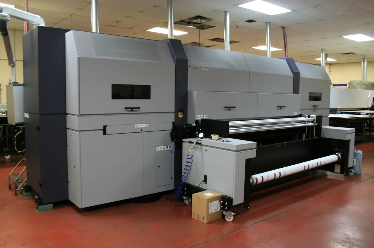 Large wide-format roll printer on a print shop production floor